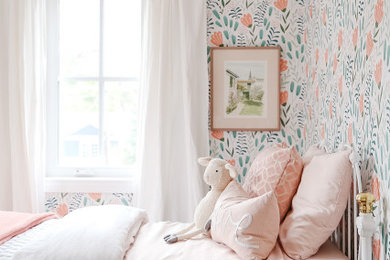 Foto de habitación de invitados tradicional renovada de tamaño medio con paredes rosas, suelo de madera en tonos medios, suelo beige y papel pintado