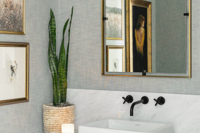 Powder room - transitional powder room idea in Sacramento with medium tone wood cabinets, marble countertops and a built-in vanity