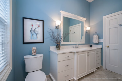 Inspiration for a mid-sized traditional kids bathroom in Milwaukee with furniture-like cabinets, white cabinets, blue walls, porcelain floors, an undermount sink, engineered quartz benchtops, multi-coloured floor and white benchtops.