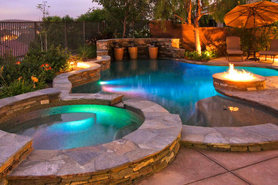 Hot tub - mid-sized contemporary backyard stone and custom-shaped aboveground hot tub idea in Orange County