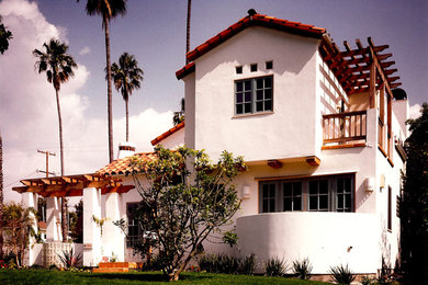 Mid-sized traditional white two-story stucco exterior home idea in Los Angeles with a tile roof and a red roof