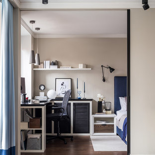 Foto på ett litet funkis arbetsrum, med beige väggar, mellanmörkt trägolv, ett inbyggt skrivbord och brunt golv