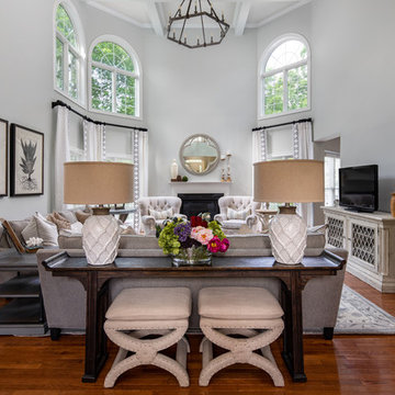 Neutral Two Story Family Room with Tufted Wing Chairs