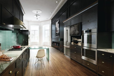 Inspiration for a large transitional galley medium tone wood floor and brown floor enclosed kitchen remodel in Other with shaker cabinets, black cabinets, granite countertops, green backsplash, glass tile backsplash, stainless steel appliances and a peninsula