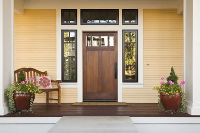 This is an example of a small craftsman front porch design in Other with decking and a roof extension.