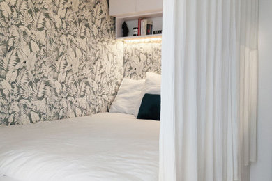 Cette image montre une petite chambre beige et blanche minimaliste avec un mur beige, parquet clair et du papier peint.