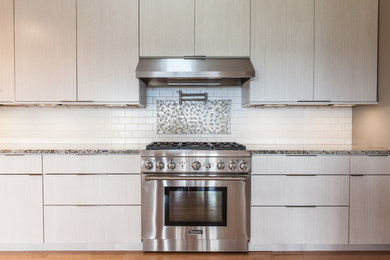 Example of a large minimalist galley light wood floor and beige floor eat-in kitchen design in Other with a double-bowl sink, gray cabinets, granite countertops, white backsplash, ceramic backsplash, stainless steel appliances and multicolored countertops