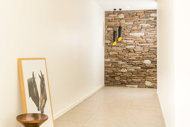 Photo of a mid-sized contemporary foyer in Brisbane with white walls, a pivot front door, grey floor and porcelain floors.