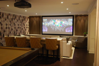 Mid-sized contemporary enclosed home theatre in Toronto with beige walls, dark hardwood floors and a projector screen.