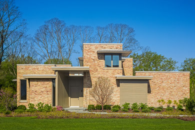 Inspiration for a large modern two-storey brick pink house exterior in Chicago with a metal roof and a flat roof.