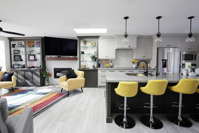 Example of a mid-sized trendy galley laminate floor and gray floor open concept kitchen design in Salt Lake City with an undermount sink, recessed-panel cabinets, gray cabinets, quartz countertops, gray backsplash, porcelain backsplash, stainless steel appliances, an island and gray countertops