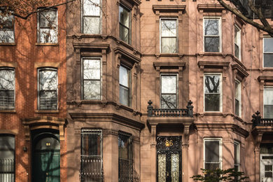 Example of a classic multicolored three-story mixed siding exterior home design in New York with a mixed material roof