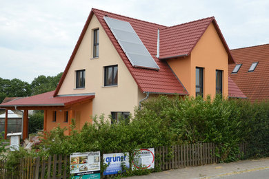 Cette photo montre une façade de maison chic avec un toit à deux pans et un toit en tuile.