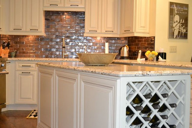Mid-sized transitional u-shaped eat-in kitchen photo in Atlanta with a double-bowl sink, raised-panel cabinets, white cabinets, granite countertops, brown backsplash, subway tile backsplash, stainless steel appliances and an island