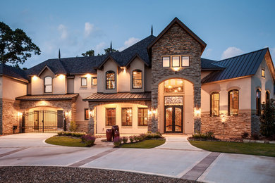 Inspiration for a huge timeless beige two-story stucco exterior home remodel in Houston