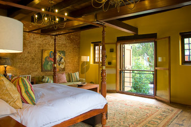Cette image montre une grande chambre parentale bohème avec un sol en bois brun.