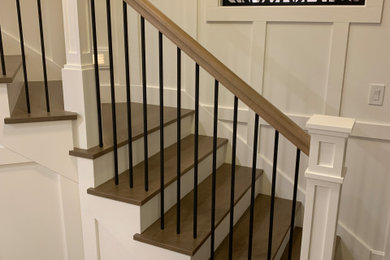 Imagen de escalera en L grande con escalones de madera, contrahuellas de madera y barandilla de varios materiales
