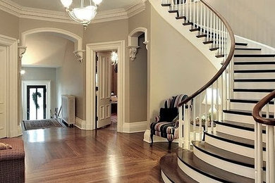 Inspiration for a large traditional wood curved staircase in Toronto with painted wood risers and wood railing.