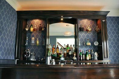 Large contemporary galley seated home bar in New York with open cabinets, dark wood cabinets and wood benchtops.