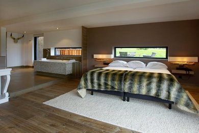 Inspiration for a large rustic master medium tone wood floor and brown floor bedroom remodel in Denver with brown walls and no fireplace