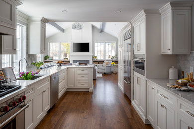 Design ideas for a traditional kitchen in Boston with an undermount sink, beaded inset cabinets, white cabinets, quartz benchtops, white splashback, marble splashback, stainless steel appliances, medium hardwood floors, brown floor and white benchtop.