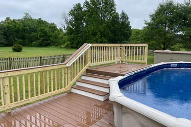 Ejemplo de piscina elevada moderna grande a medida en patio trasero con paisajismo de piscina