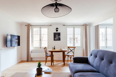 Idée de décoration pour un salon blanc et bois tradition de taille moyenne et ouvert avec un mur blanc, parquet clair, une cheminée standard, un téléviseur fixé au mur et un manteau de cheminée en bois.