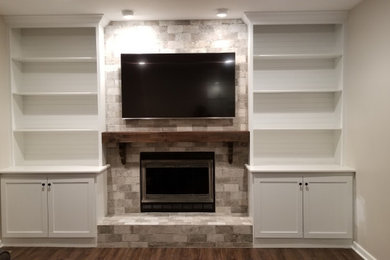 Living room library - mid-sized farmhouse enclosed dark wood floor and brown floor living room library idea in Orange County with beige walls, a standard fireplace, a brick fireplace and a wall-mounted tv