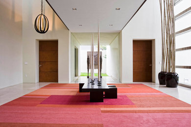 Photo of an expansive contemporary foyer with beige walls and limestone floors.