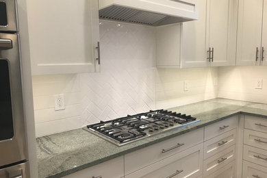 Inspiration for a transitional light wood floor eat-in kitchen remodel in Bridgeport with shaker cabinets, white cabinets, granite countertops, white backsplash, subway tile backsplash, stainless steel appliances, an island and green countertops