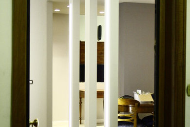 Immagine di una porta d'ingresso design di medie dimensioni con pareti grigie, parquet chiaro e una porta in legno bruno
