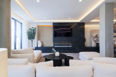 Imagen de dormitorio principal y gris y blanco minimalista de tamaño medio con paredes beige, suelo de madera clara y todas las chimeneas