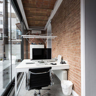 Photo of a small industrial study room in Barcelona with concrete floors, a built-in desk, orange walls and no fireplace.