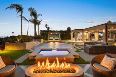 Design ideas for a large mediterranean full sun backyard stone landscaping in San Diego with a fire pit.
