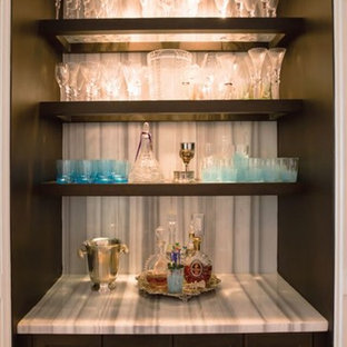 マイアミの中サイズのコンテンポラリースタイルのおしゃれなウェットバー (シンクなし、落し込みパネル扉のキャビネット、茶色いキャビネット、ライムストーンカウンター、白いキッチンパネル、石スラブのキッチンパネル) の写真