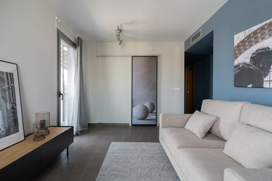 Imagen de salón contemporáneo de tamaño medio con paredes azules, suelo de baldosas de cerámica, suelo gris y alfombra