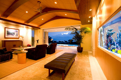 Large trendy enclosed limestone floor living room photo in Hawaii with beige walls and a concealed tv