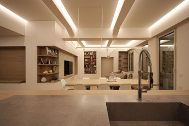 Ispirazione per un grande soggiorno nordico stile loft con libreria, pareti bianche, pavimento in legno massello medio, parete attrezzata, pavimento marrone, soffitto ribassato e pannellatura