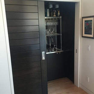 小さいモダンスタイルのおしゃれなウェットバー (一体型シンク、オープンシェルフ、黒いキャビネット、ステンレスカウンター、マルチカラーのキッチンパネル、淡色無垢フローリング、ベージュの床) の写真