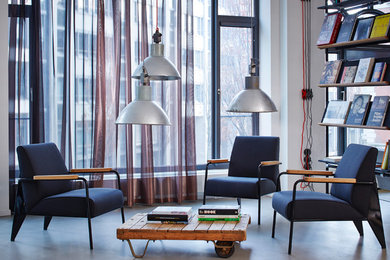 Mittelgroße Industrial Bibliothek im Loft-Stil mit weißer Wandfarbe und Betonboden in Berlin