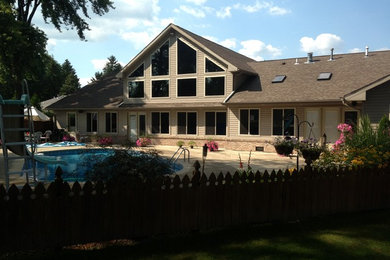 Example of a mid-sized classic beige two-story brick exterior home design in Other with a shingle roof
