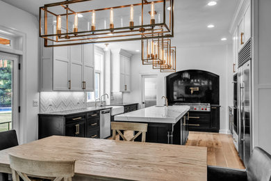Eat-in kitchen - large transitional u-shaped medium tone wood floor and brown floor eat-in kitchen idea in New York with a farmhouse sink, shaker cabinets, white cabinets, quartz countertops, white backsplash, ceramic backsplash, stainless steel appliances, an island and white countertops