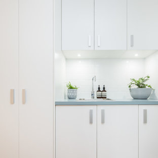 Small traditional single-wall separated utility room in Canberra - Queanbeyan with a built-in sink, white cabinets, laminate countertops, white walls, light hardwood flooring, an integrated washer and dryer, beige floors and turquoise worktops.