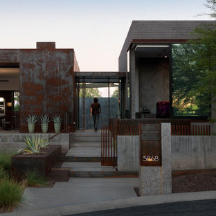 Bild på ett stort funkis flerfärgat hus, med två våningar, platt tak och metallfasad