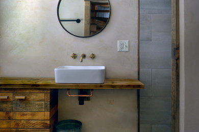 Bathroom - small scandinavian 3/4 gray tile and ceramic tile ceramic tile, gray floor and single-sink bathroom idea in Burlington with distressed cabinets, a two-piece toilet, beige walls, a vessel sink, wood countertops and a built-in vanity