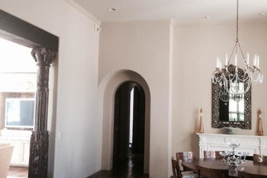 This is an example of a large classic enclosed dining room in Phoenix with beige walls, dark hardwood flooring, a standard fireplace and a plastered fireplace surround.
