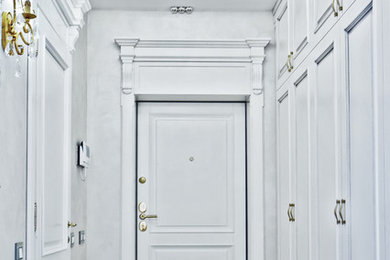 Стильный дизайн: прихожая в классическом стиле с белыми стенами, мраморным полом и белой входной дверью - последний тренд