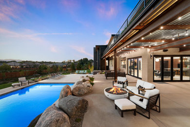 Источник вдохновения для домашнего уюта: большой прямоугольный ландшафтный бассейн на заднем дворе в стиле модернизм с покрытием из бетонных плит
