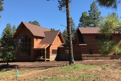 Large mountain style brown two-story wood exterior home photo in Albuquerque with a shingle roof