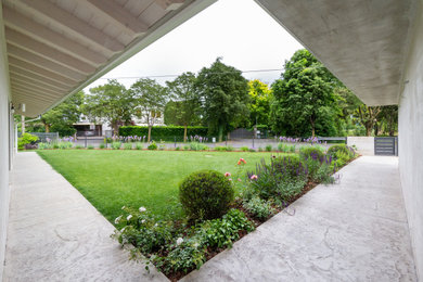 Ispirazione per un grande giardino mediterraneo esposto in pieno sole davanti casa in primavera con pavimentazioni in cemento e recinzione in metallo